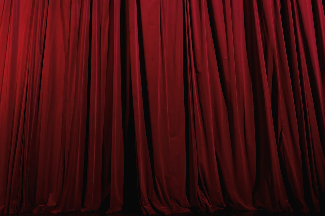 Rich red curtains with elegant drapery, perfect for theater or luxury decor themes.